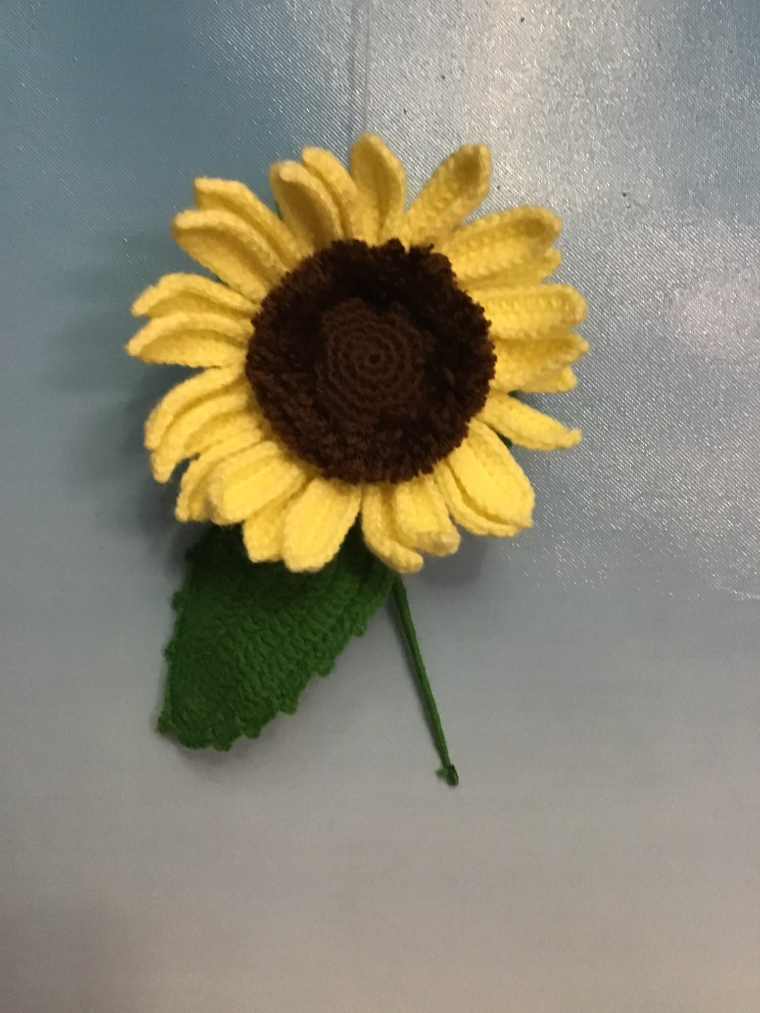 Large crocheted sunflower with green leaf