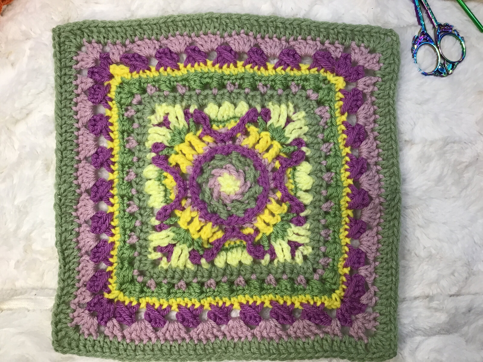 Detailed crocheted Marley Mae square in purple, green, and yellow